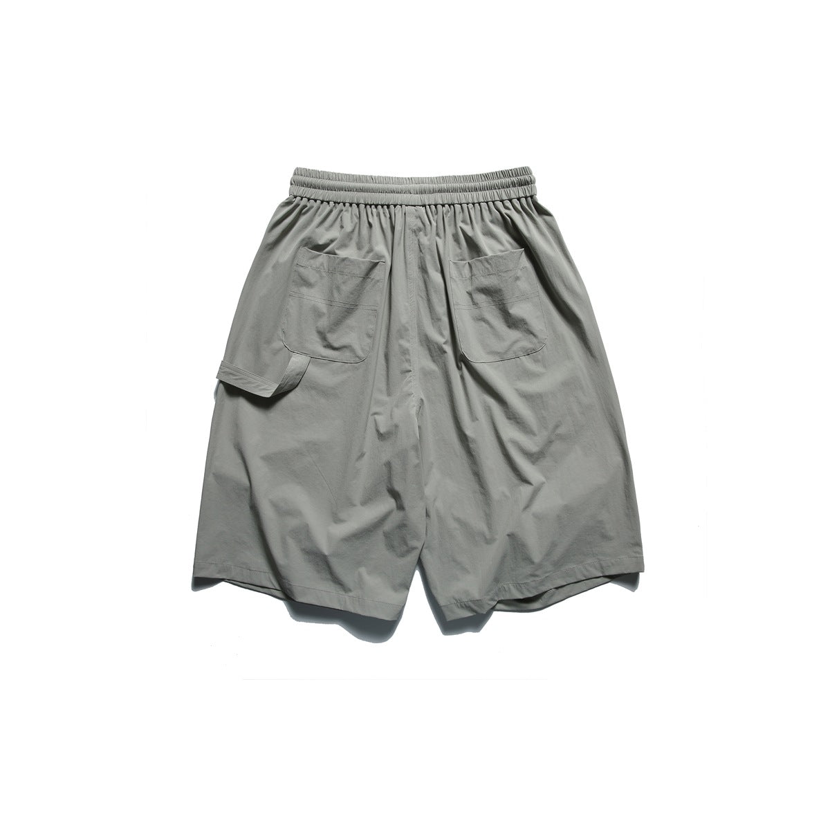 Back view of loose gray-green shorts with an elastic waistband and two large patch pockets.