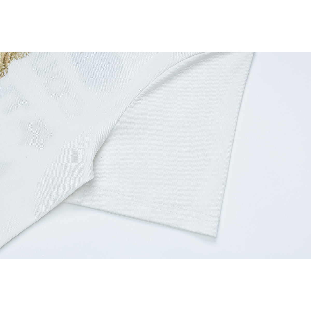 Close-up of a white T-shirt sleeve and stitched hem, with part of the printed design at the edge.