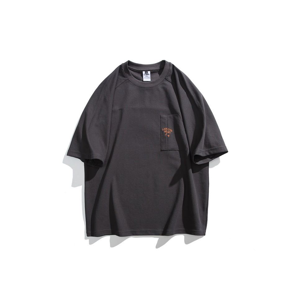 Front view of a charcoal oversized short-sleeve T-shirt with a crew neck and small tan lettering on the chest pocket.