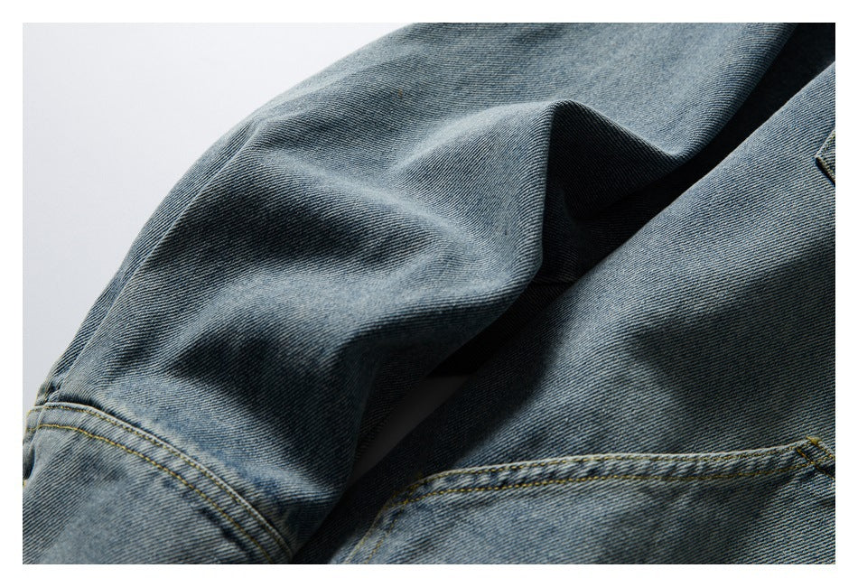 Close-up of blue denim jacket fabric and stitched sleeve seams.