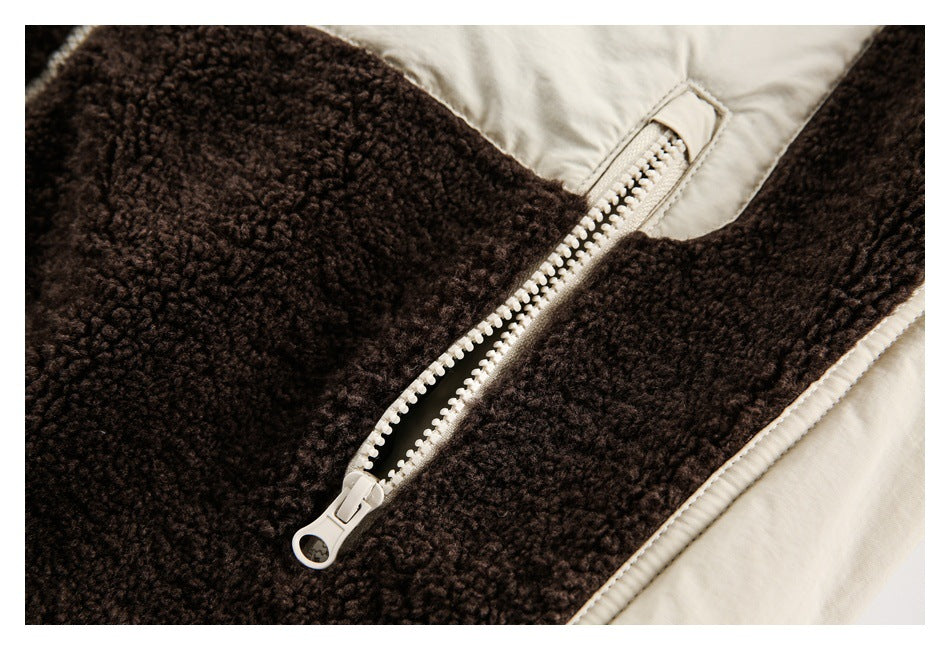 Close-up of an open cream zipper running through dark brown curly fleece.