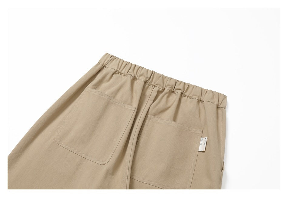 Upper back of beige pants with an elastic waistband and two patch pockets.
