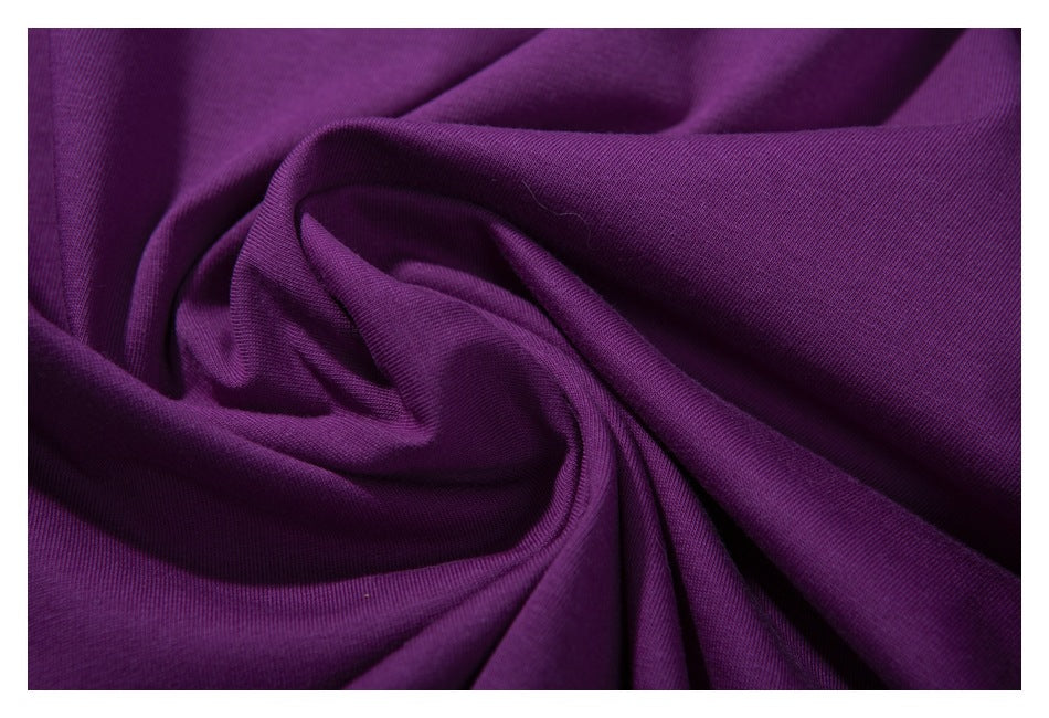Close-up of purple fabric draped in folds, showing its surface texture.
