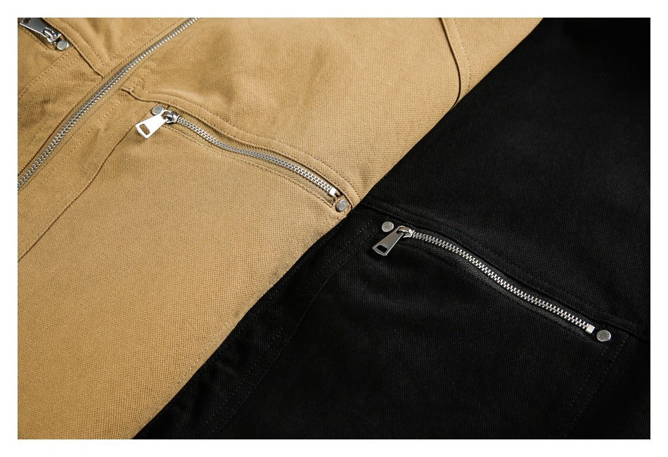 Close-up of tan and black jacket panels with silver diagonal and zippered pockets.