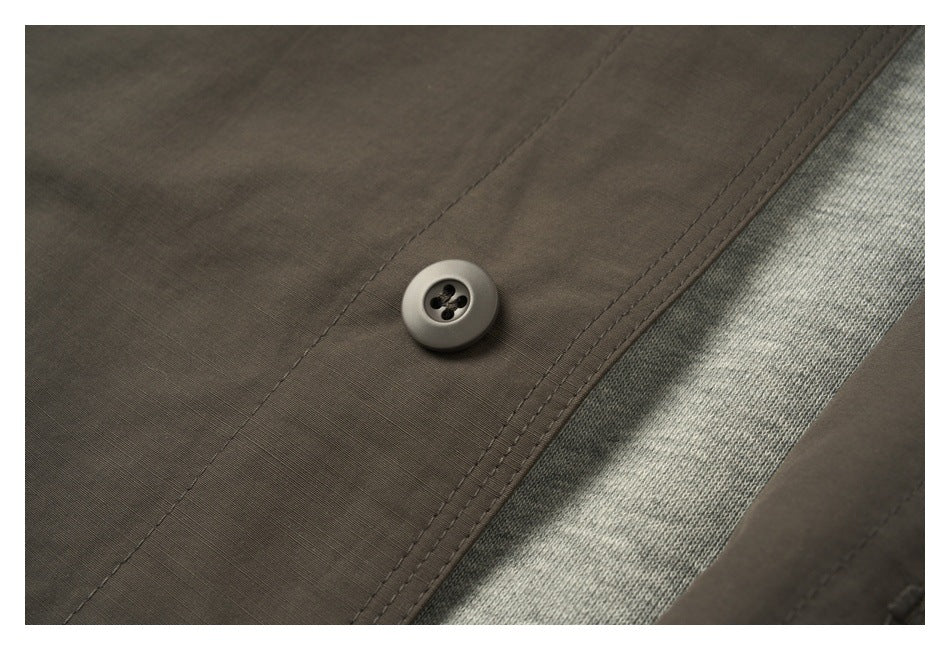 Close-up of a dark button, double stitching, and gray knit lining on the garment.