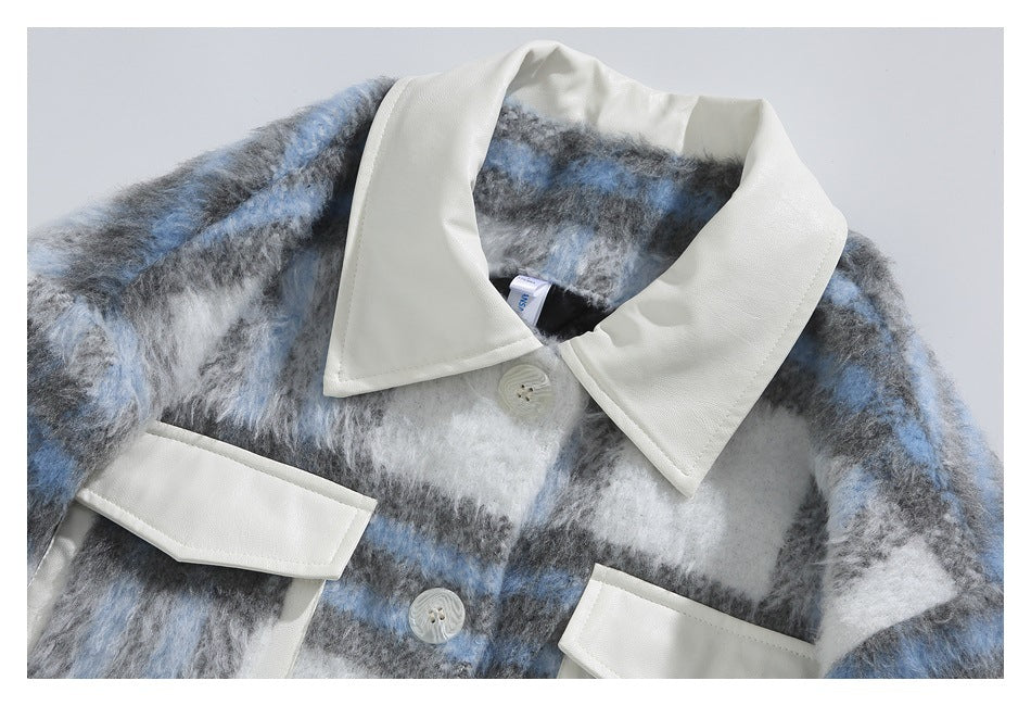 Close-up of the jacket's white pointed collar, front buttons, and white-trimmed chest pockets against plaid fabric.