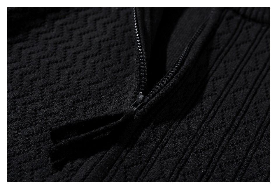Close-up of a black textured knit garment with a black zipper.