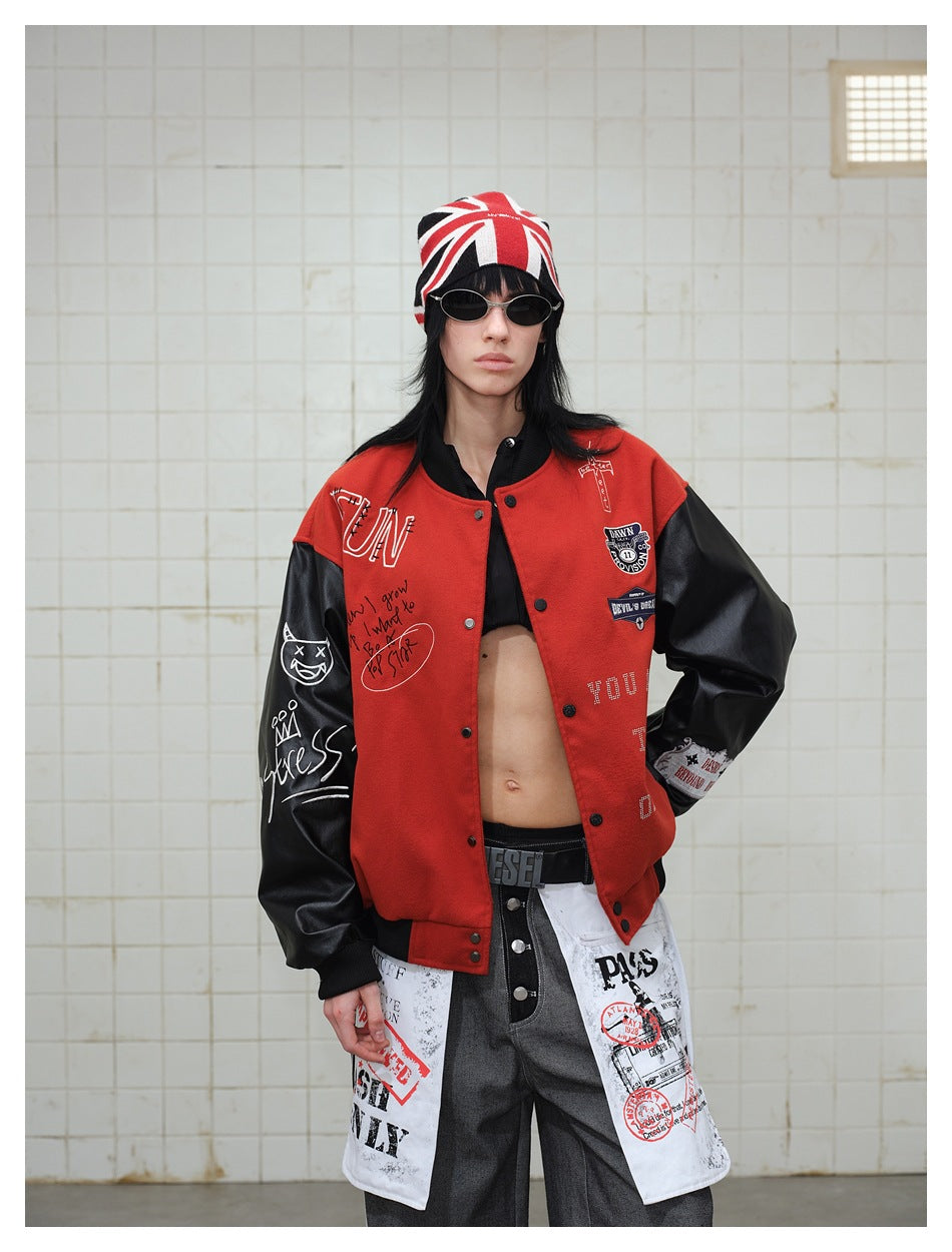 Model wearing the red varsity jacket open over a black top, showing chest patches and black leather-look sleeves
