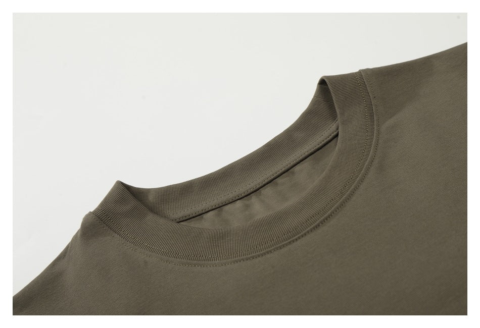 Close-up of the olive-brown T-shirt's ribbed crew neckline and shoulder stitching.