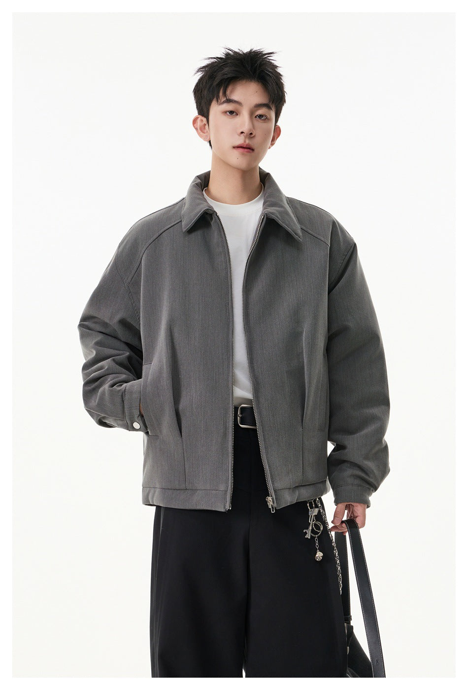 Front view of a model wearing an open gray zip-front jacket with a pointed collar and roomy sleeves.