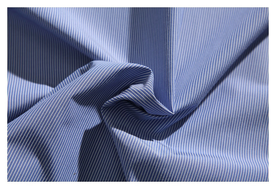 Close-up of blue fabric with fine white vertical stripes, draped into folds.