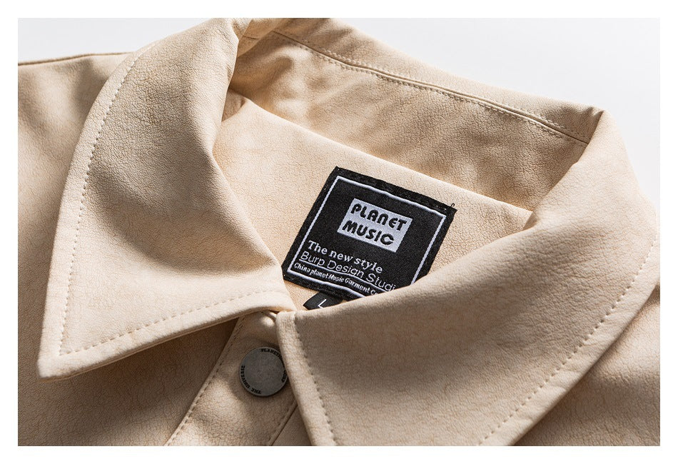 Close-up of a cream jacket's pointed collar, button, and sewn neck label with English text.