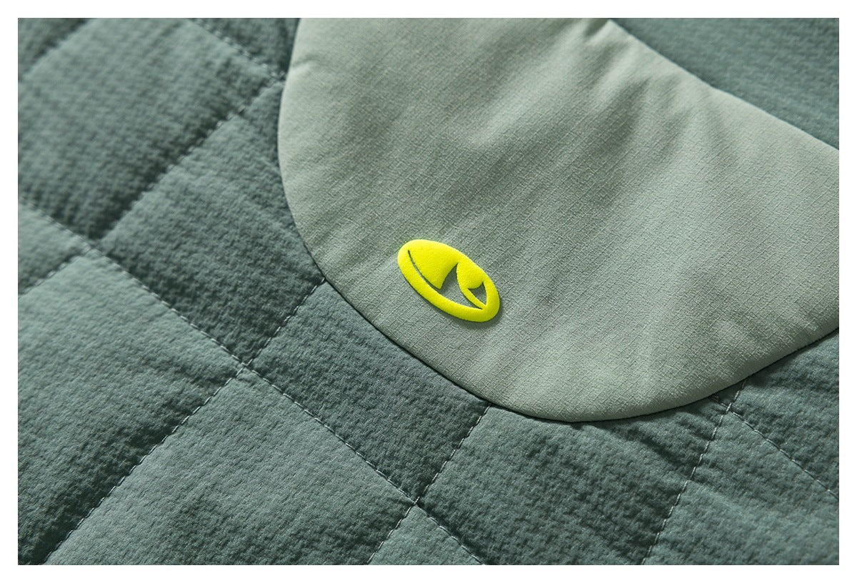 Macro view of a bright yellow emblem on a light green panel beside dark green quilting.