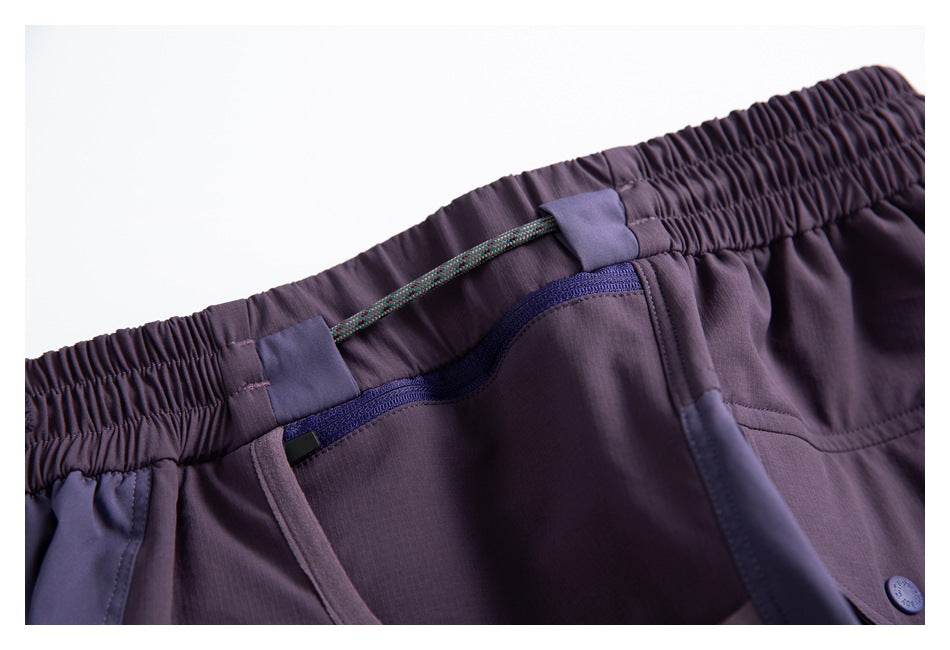 Close-up of the purple shorts' elastic waistband, drawcord, and zippered pocket.