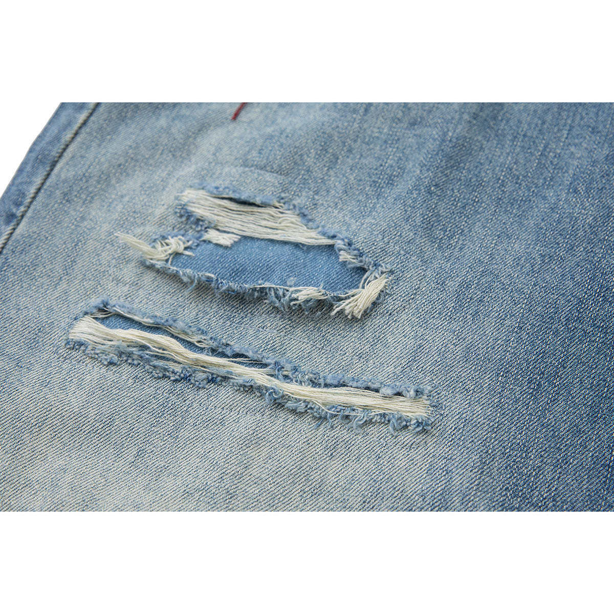 Close-up of light blue denim shorts with two frayed distressed rips.
