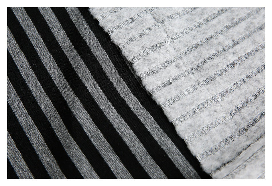 Close-up of black fabric with gray stripes beside fuzzy light gray fabric with narrow gray stripes.