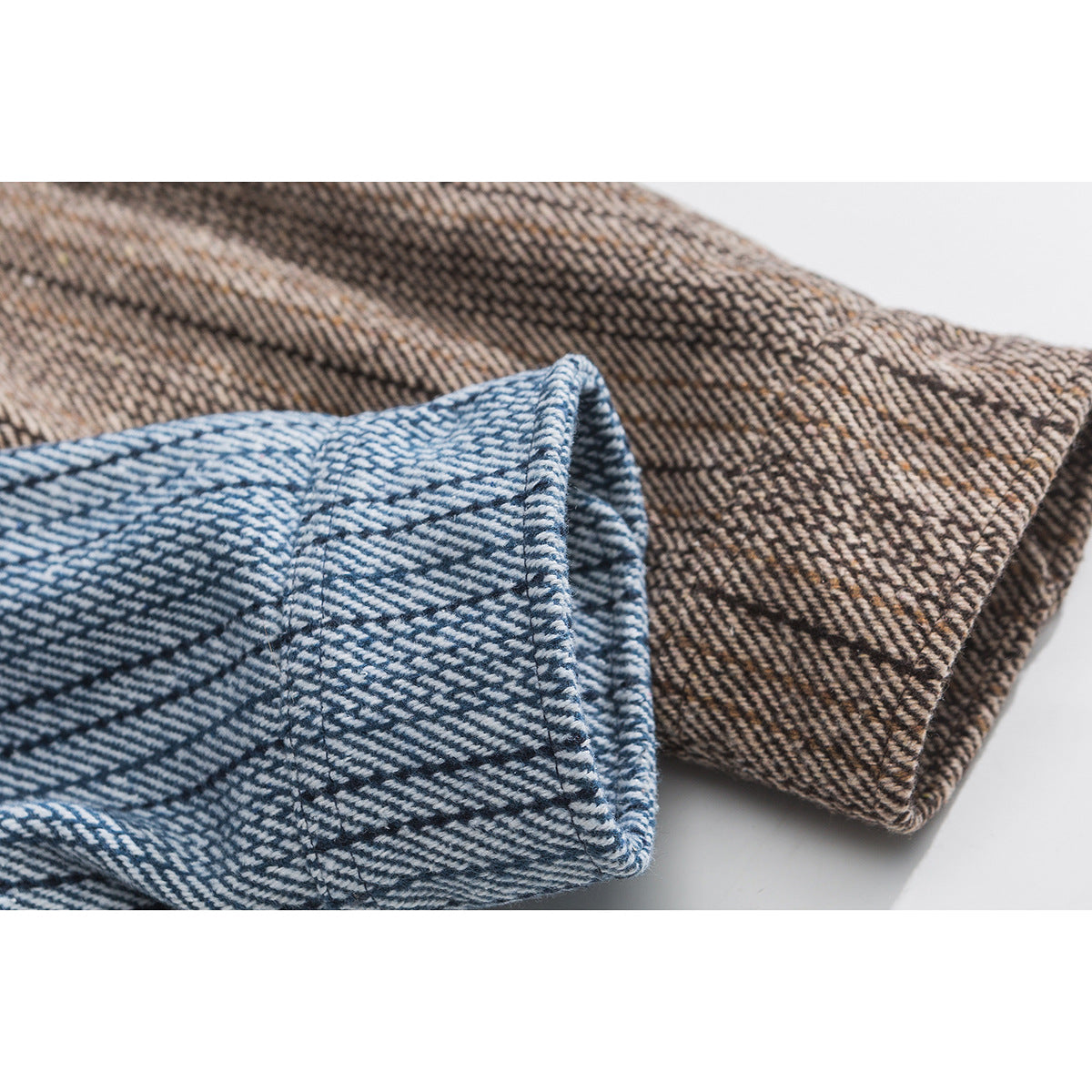 Close-up of folded blue and brown striped shirt cuffs showing their stitched edges.