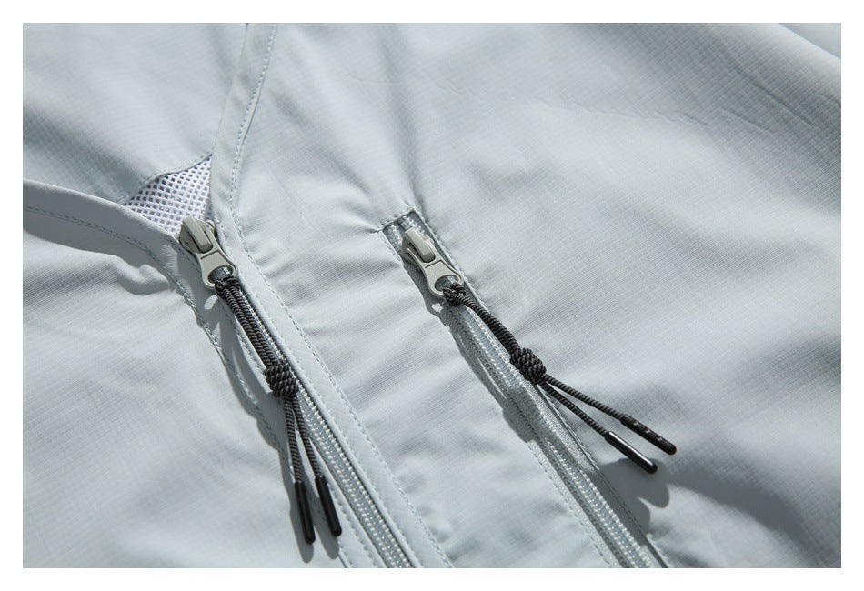 Close-up of the pale gray jacket's central zipper and adjacent vertical zip pocket with black pull cords.