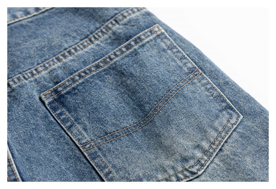 Close-up of a rear pocket on blue washed jeans with contrast stitching.