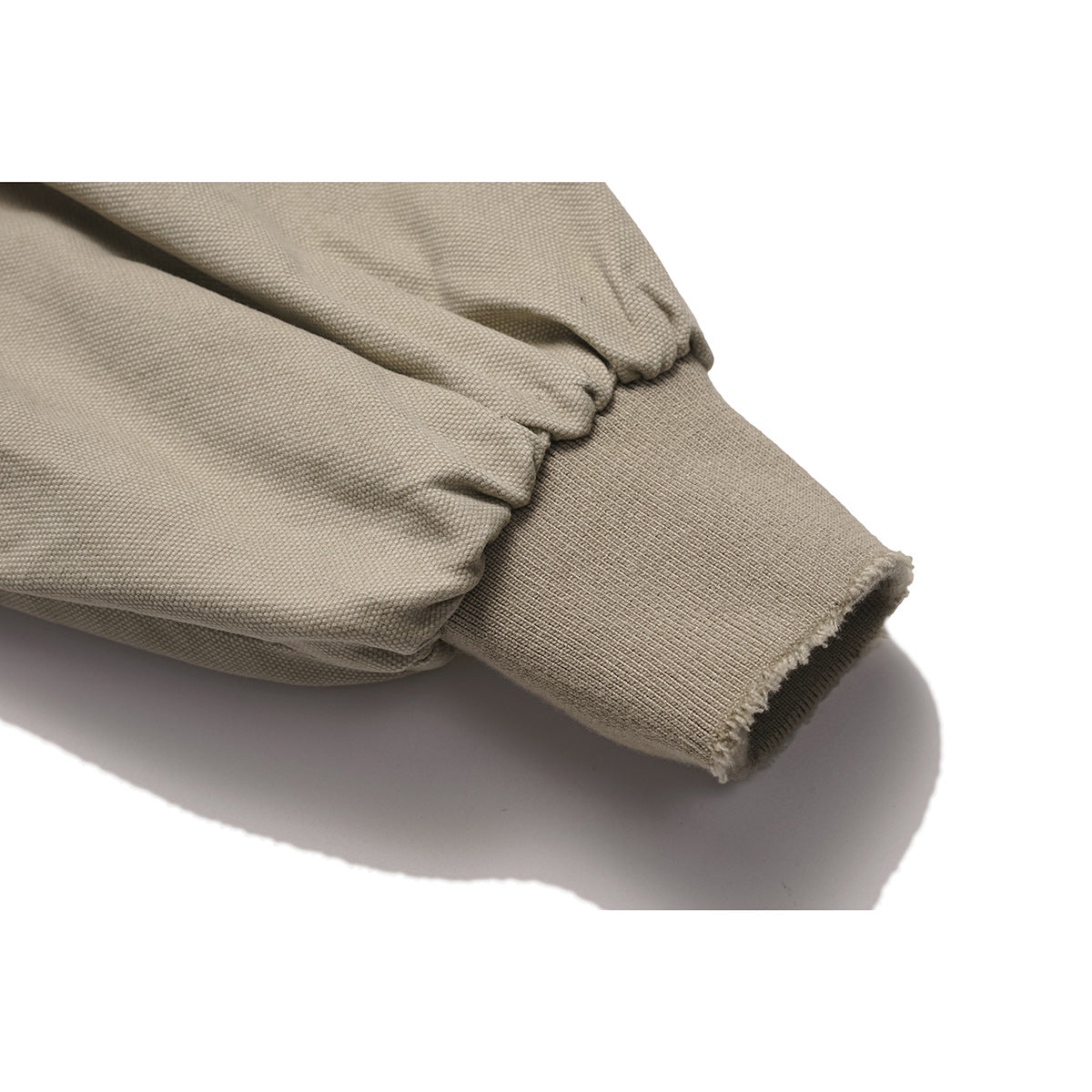Close-up of the taupe jacket’s gathered sleeve and ribbed cuff.