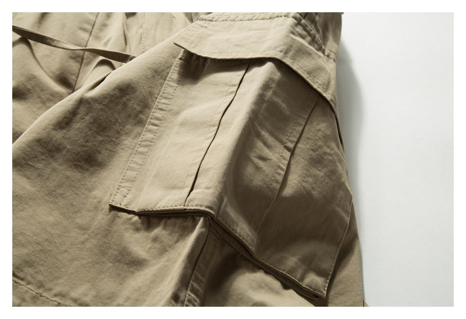 Close-up of a large flap cargo pocket and seams on tan trousers.