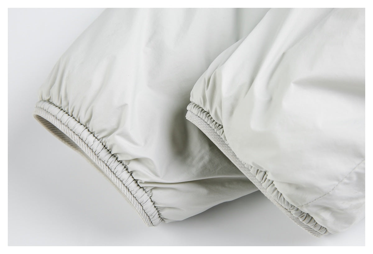 Close-up of pale gray jacket edges with gathered elastic and ribbed trim.