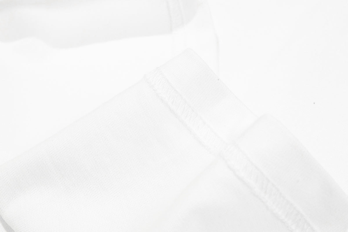 Close-up of white fabric with a diagonal stitched seam and textured surface.