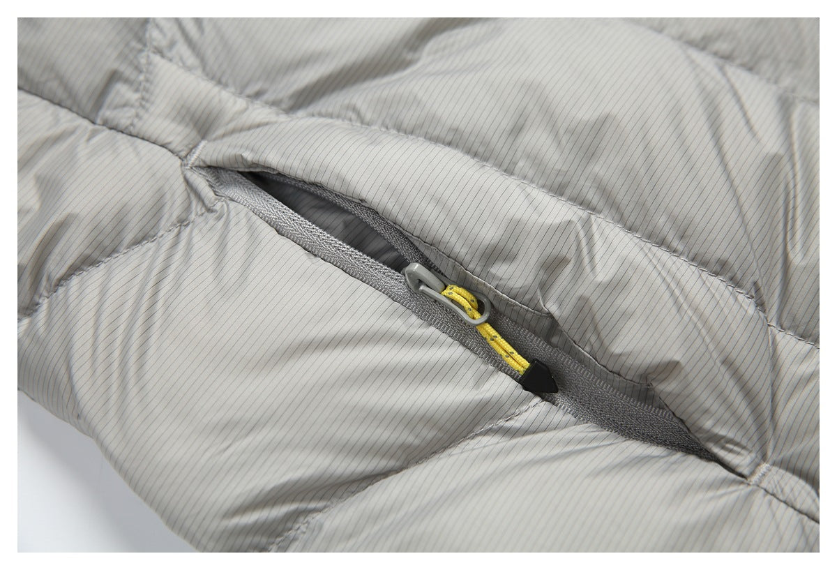 Close-up of a gray zipper with a yellow pull on a light gray pinstriped quilted jacket.