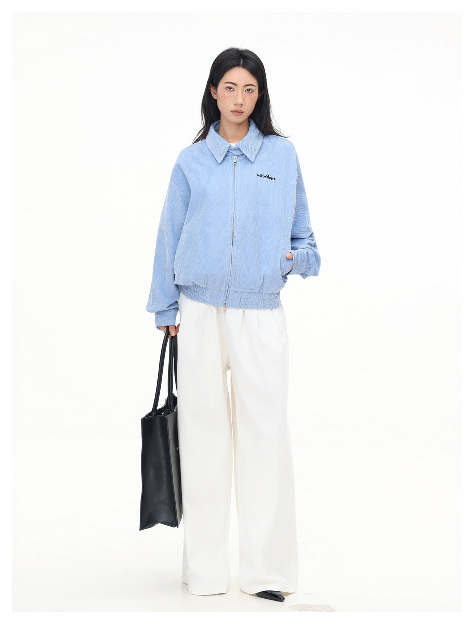 Full-length model wearing a light blue zip jacket with a pointed collar and white wide-leg trousers.
