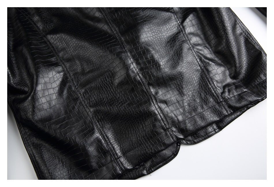 Close-up of glossy black crocodile-embossed garment panels with vertical seams and a curved edge.