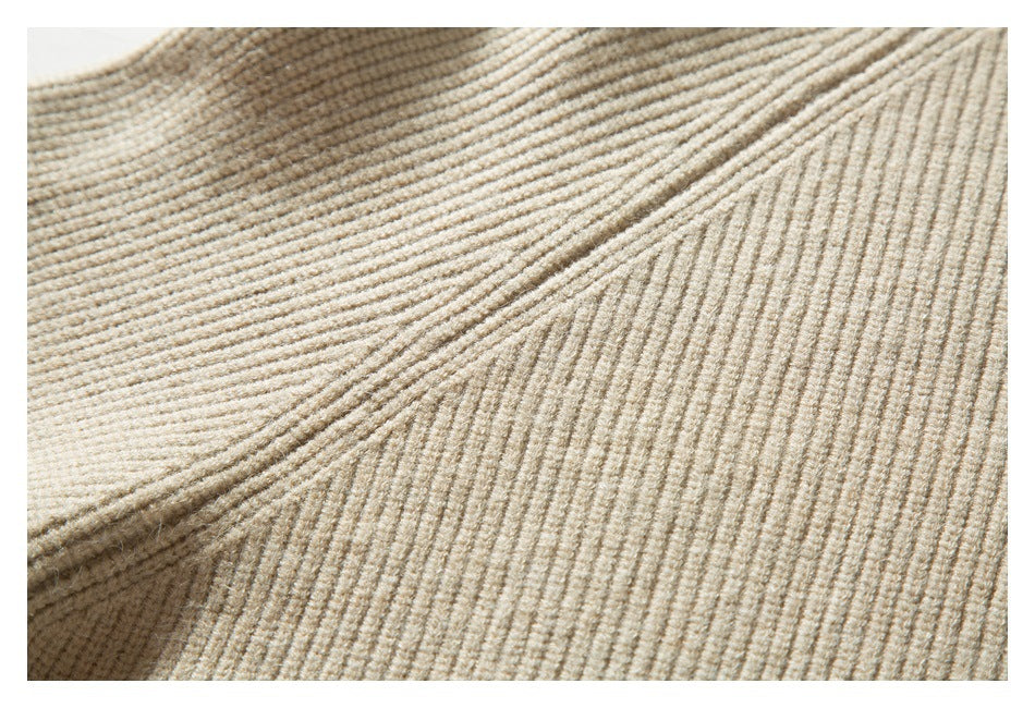 Close-up of the beige sweater's textured knit and ribbed seam near the shoulder.