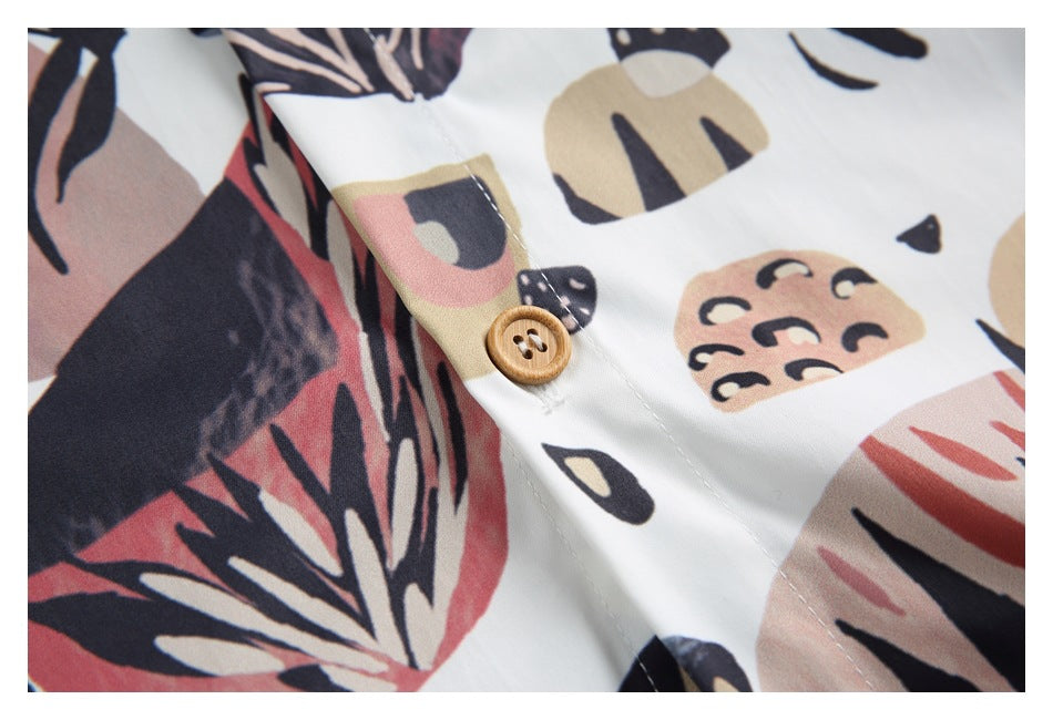 Close-up of a tan button and buttonhole on the shirt's abstract printed fabric.