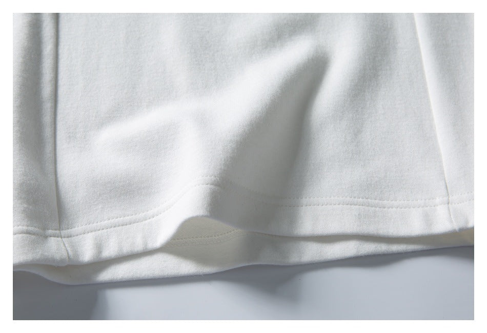 Close-up of the stitched bottom hem of a white garment, showing the folded edge.