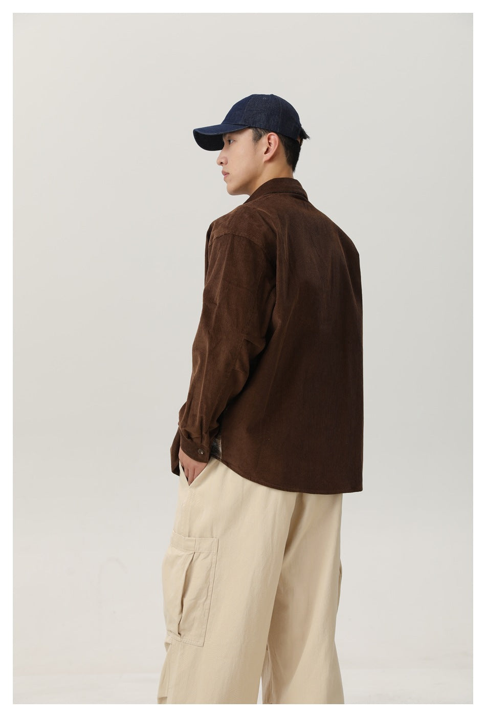 Closer rear three-quarter view showing the brown shirt's back and the cream cargo pants' side pocket.