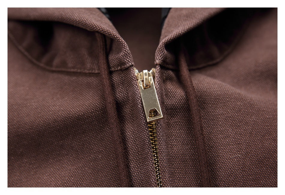Close-up of the brown hoodie’s gold-tone front zipper and matching drawstrings.
