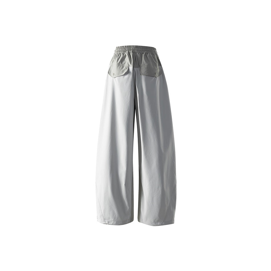 Rear view of light gray wide-leg pants with an elastic waist and two flap back pockets.