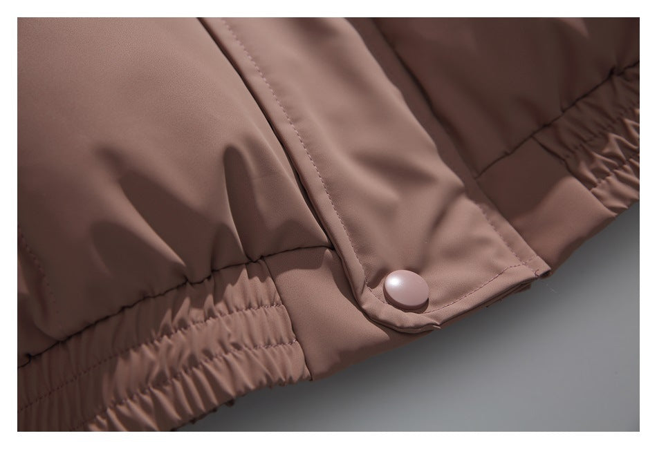 Close-up of the jacket's taupe-brown snap tab and gathered elastic hem.
