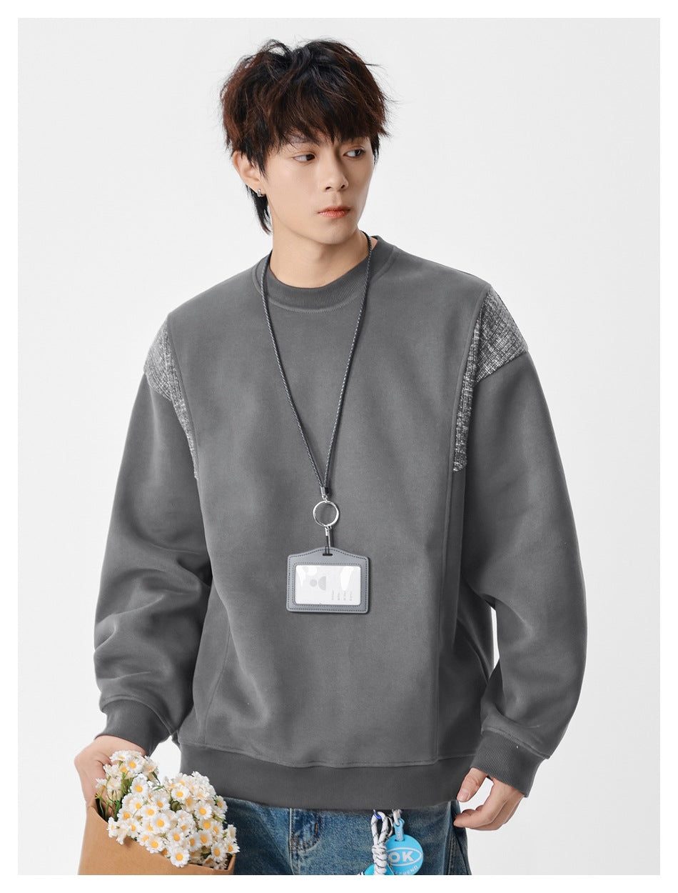 Model wearing a charcoal gray crewneck sweatshirt with textured shoulder panels and ribbed trim.