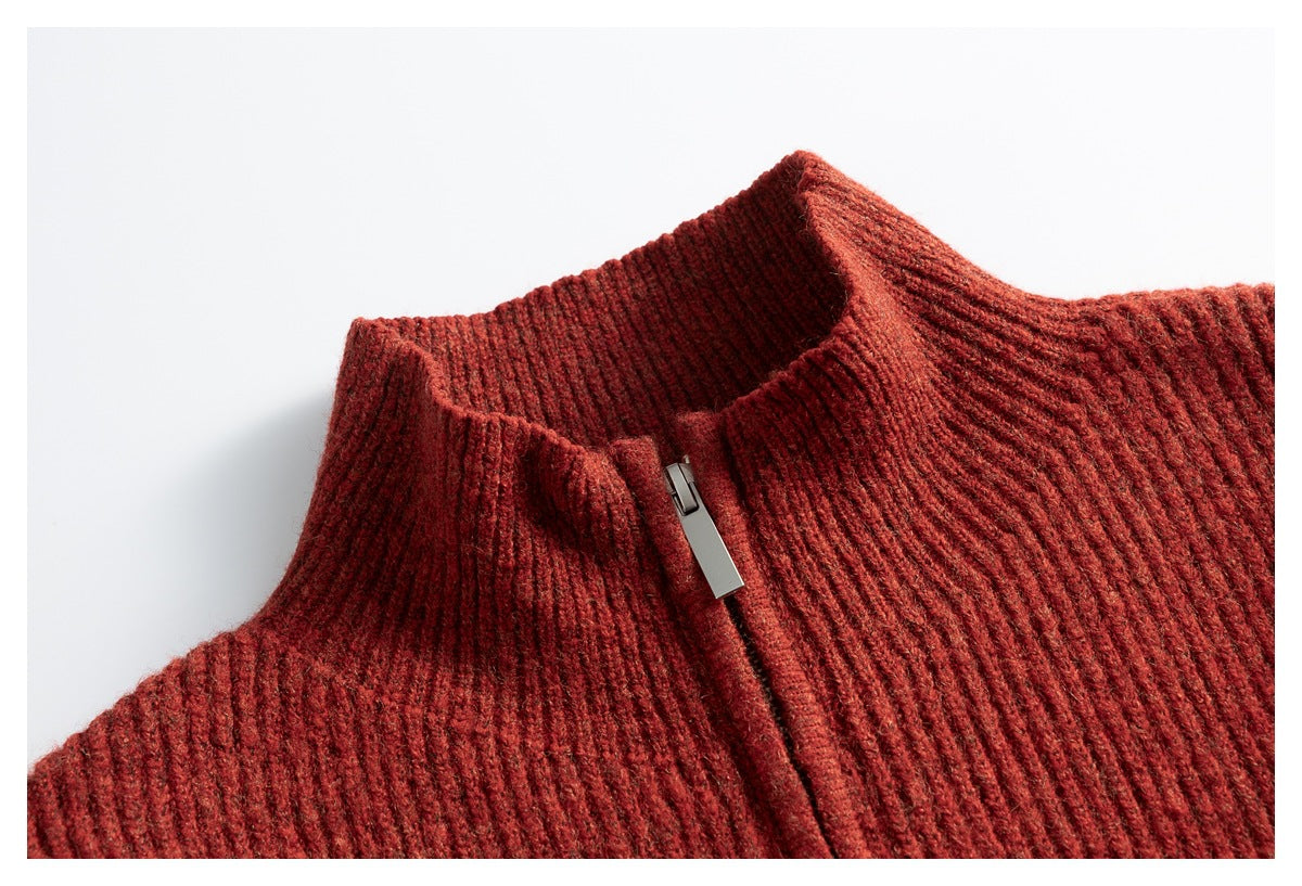 Close-up of a rust-red rib-knit sweater's high collar and front zipper.