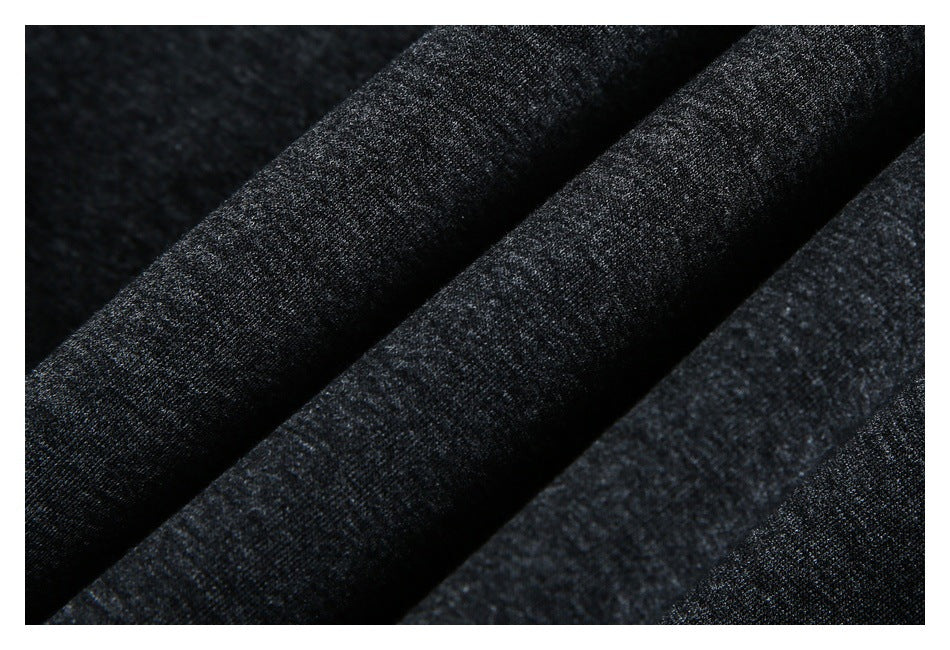 Close-up of dark charcoal gray fabric with a fine heathered knit texture arranged in folds.