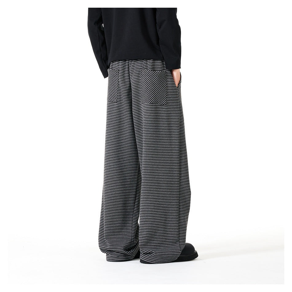 Back view of a model wearing loose black-and-white striped trousers with two back pockets.