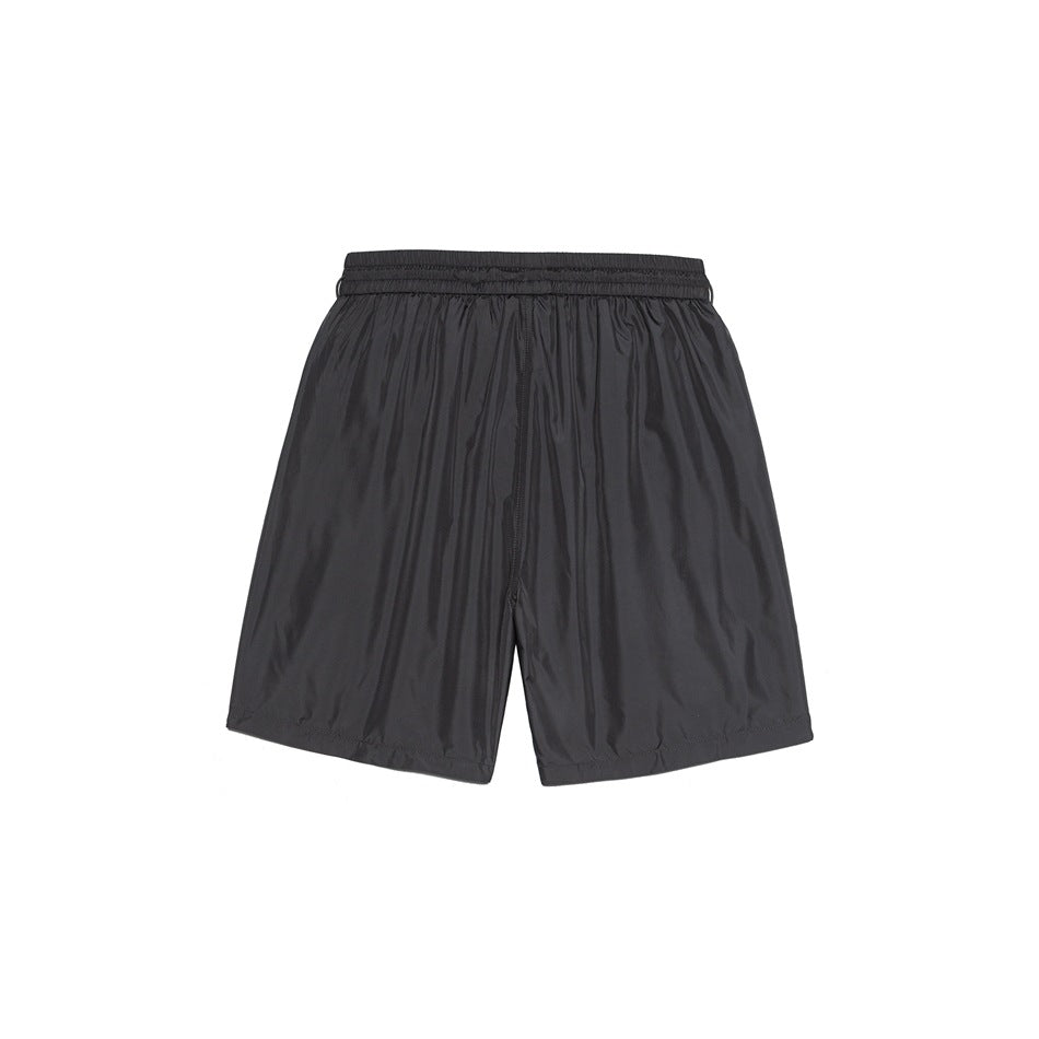 Back view of dark gray shorts with elastic waistband and center back seam on smooth fabric
