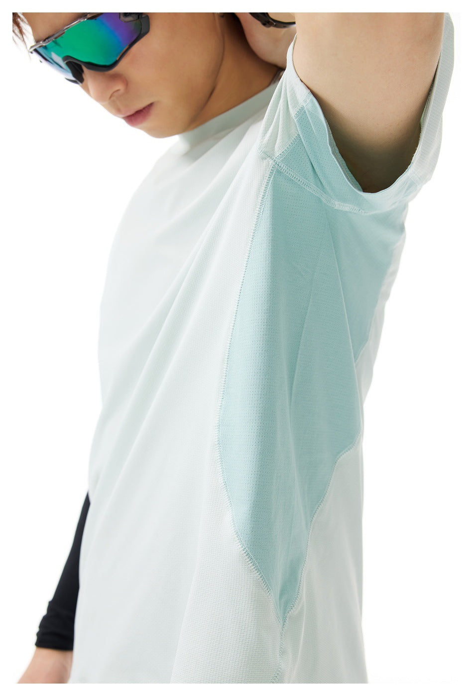 Close-up of a pale mint T-shirt showing the underarm mesh panel, seams, and fabric texture.