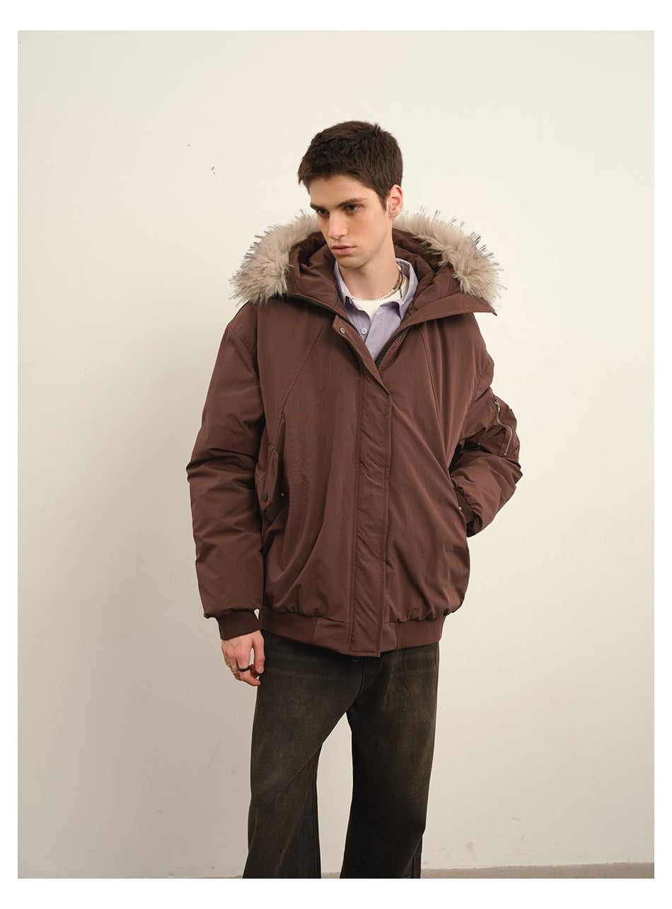 Model in dark red hooded jacket with fur-like trim, hand in pocket, over lavender shirt and dark jeans