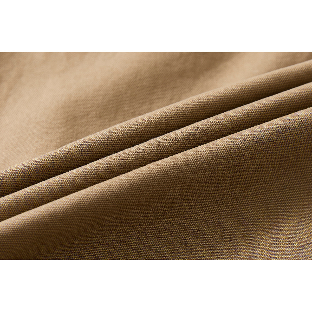 Macro view of tan fabric folded to show its woven surface and texture.