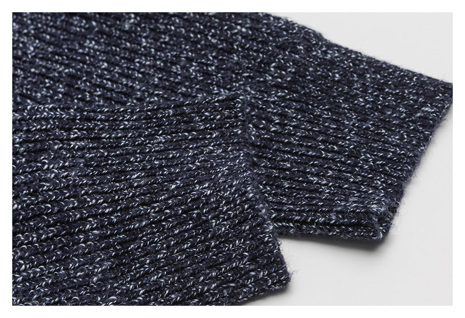 Close-up of a dark navy marled knit sleeve cuff with ribbed stitching.