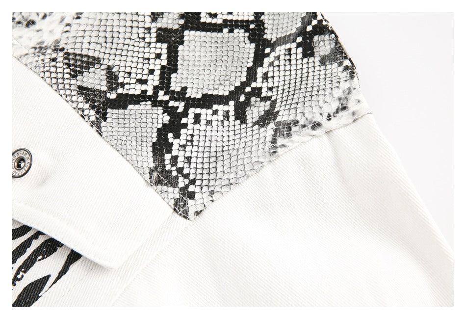 Close-up of a black-and-white snakeskin-pattern panel beside plain white denim.