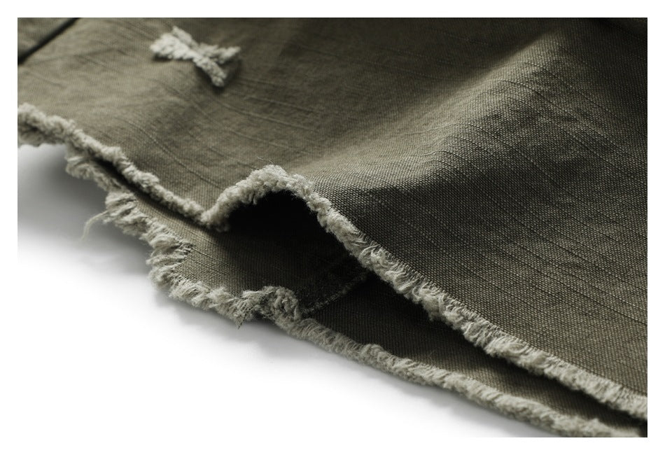 Close-up of olive trouser fabric and a heavily frayed, raw edge.