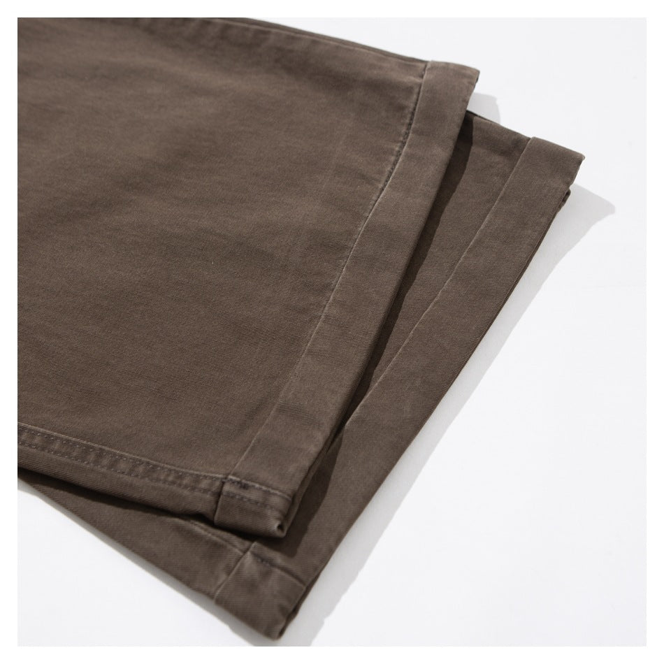 Close-up of the folded hems on dark brown trouser legs.