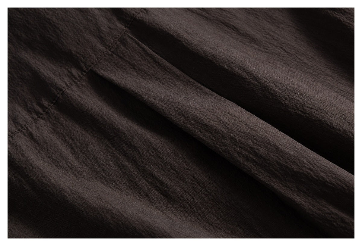Close-up showing the dark brown shirt fabric and stitched seam.